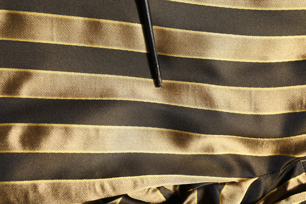 Pantalones con pernera entallada de satén a rayas doradas y negras de Dolce & Gabbana